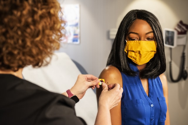 Woman in mask getting vaccinated